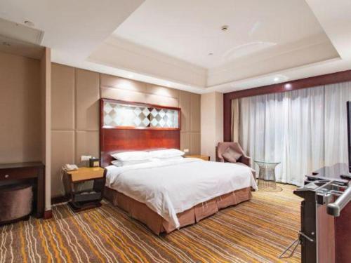 a hotel room with a large bed and a television at Hohhot Hai Liang Plaza Hotel in Hohhot