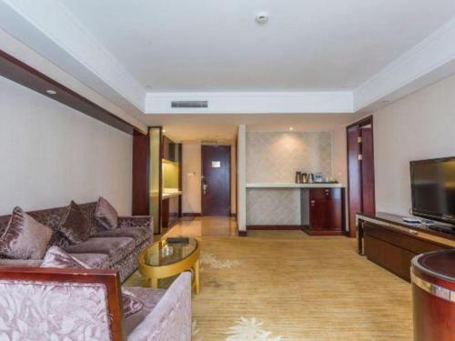 a living room with a couch and a tv at Hohhot Hai Liang Plaza Hotel in Hohhot