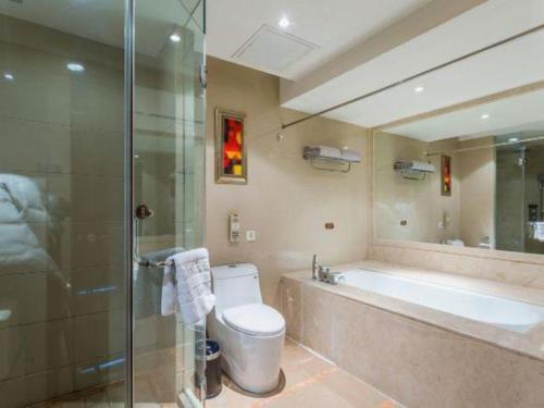 a bathroom with a tub and a toilet and a shower at Hohhot Hai Liang Plaza Hotel in Hohhot