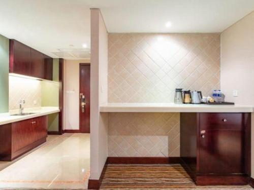 a kitchen with a sink and a counter top at Hohhot Hai Liang Plaza Hotel in Hohhot