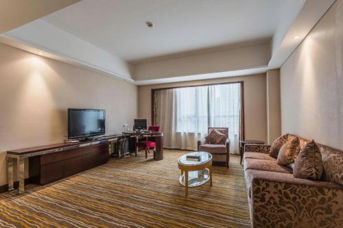 a living room with a couch and a flat screen tv at Hohhot Hai Liang Plaza Hotel in Hohhot