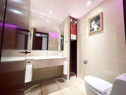 a bathroom with a sink and a toilet and a mirror at Hohhot Hai Liang Plaza Hotel in Hohhot