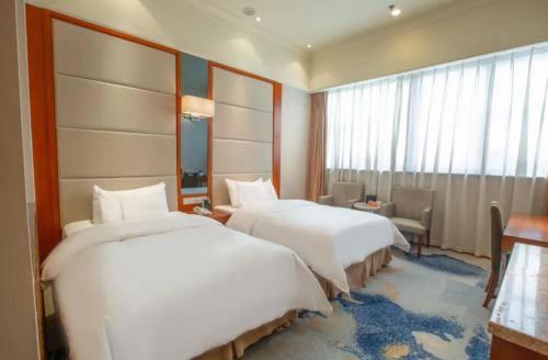 a hotel room with two beds and a window at Linyi Blue Horizon Intenational Hotel in Linyi