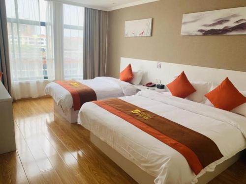 a hotel room with two beds and a window at Shell Shanghai Songjiang District Xinqiao Town Xinqiao Hotel in Chunshen