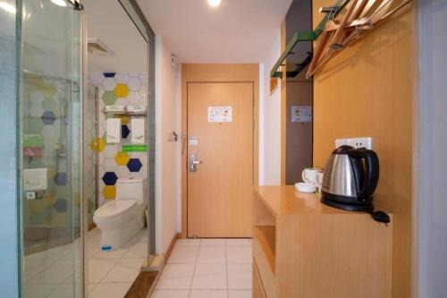 a bathroom with a shower and a toilet and a sink at Vatica Hefei Feidong County Yuzhou Central Square Hotel in Hefei