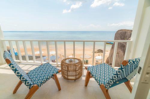 a balcony with chairs and a view of the beach at Ibiza Beach Club Koh Tao in Koh Tao