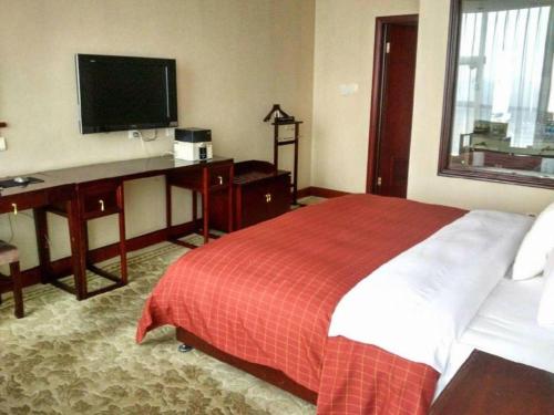 a bedroom with a bed and a desk and a television at Datong Tiangui International Hotel in Datong