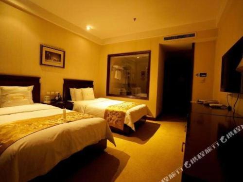 a hotel room with two beds and a television at Datong Tiangui International Hotel in Datong