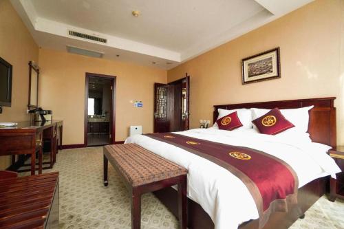 a bedroom with a large bed and a desk at Datong Tiangui International Hotel in Datong