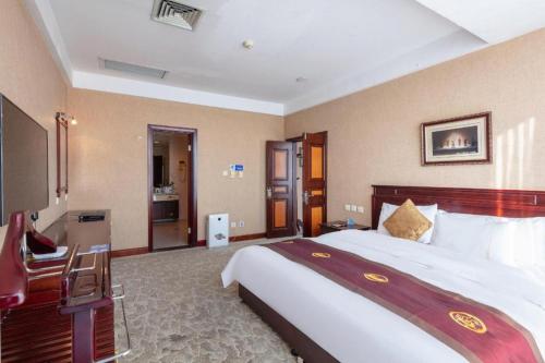 a bedroom with a large bed in a hotel room at Datong Tiangui International Hotel in Datong