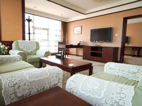 a living room with a couch and a tv at Datong Tiangui International Hotel in Datong