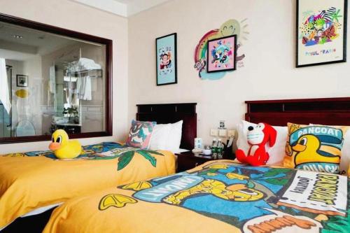 two beds with stuffed animals on them in a bedroom at Datong Tiangui International Hotel in Datong