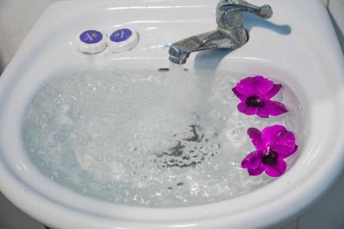 a sink with a faucet and purple flowers in it at Green Ocean Koh Rong in Koh Rong Island
