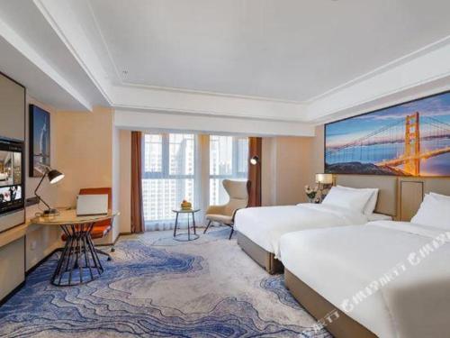 a hotel room with two beds and a tv at Vienna Hotel Tianjin Guizhou Road Branch in Tianjin