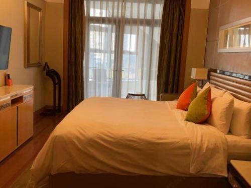 a bedroom with a large white bed and a window at Dusit D2 Binhu Changzhou Hotel in Changzhou