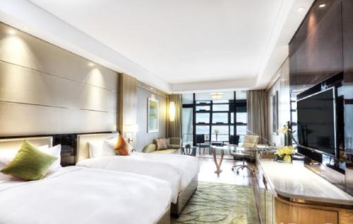 a hotel room with two beds and a living room at Dusit D2 Binhu Changzhou Hotel in Changzhou