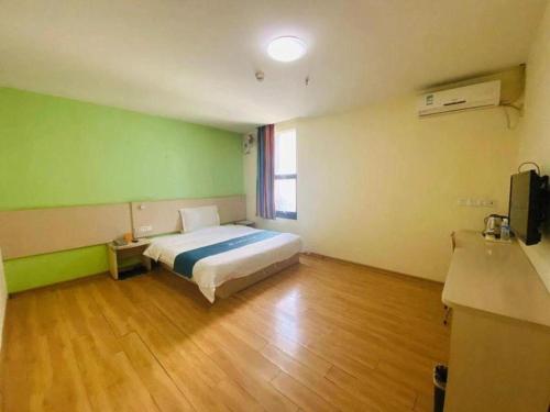 a bedroom with a bed in a room with green walls at 7 Days Inn Xi'an North Economic Development Zone 4th Fengcheng Road in Xi'an