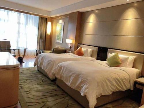 a hotel room with a large bed with a large headboard at Dusit D2 Binhu Changzhou Hotel in Changzhou