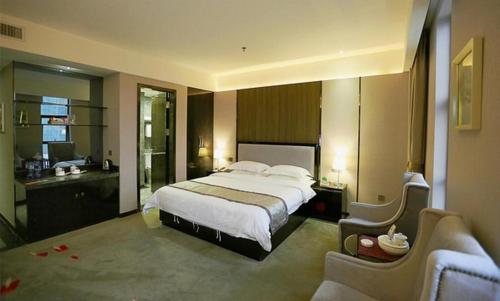 a bedroom with a large bed and a bathroom at Shantou Grandtide Hotel in Shantou