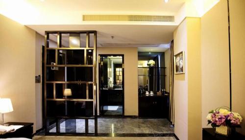 a living room with a large glass door to a room at Shantou Grandtide Hotel in Shantou