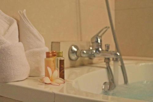 a bathroom sink with a faucet and two bottles at Royal Lee Resort and Spa in Ban Bo Han