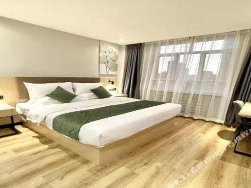 a bedroom with a large bed and a large window at GreenTree Inn Xinjiang Uygur Autonomous Region Korla Bazhou Bus Terminal Beishan Road Express Hotel in Korla