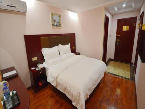 a bedroom with a large white bed and a phone at GreenTree Inn Suzhou Shihu Suli Road Express Hotel in Suzhou