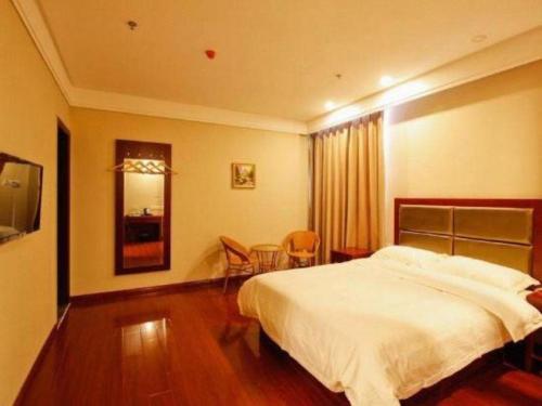 a bedroom with a bed and a table and chairs at GreenTree Inn Hefei Huangshan Road Daxidi 1912 Express Hotel in Hefei