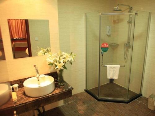 a bathroom with a sink and a shower at GreenTree Inn Lanzhou Yantan Road Express Hotel in Lanzhou