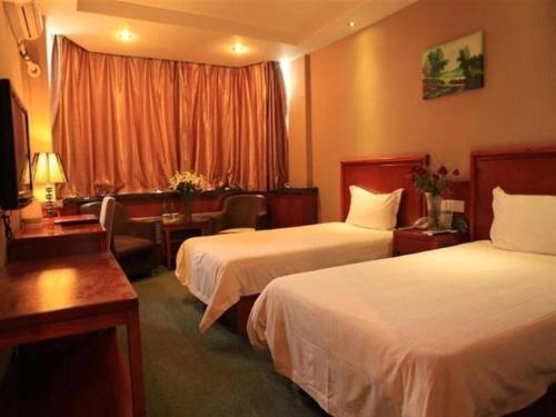 a hotel room with two beds and a desk at GreenTree Inn Lanzhou Yantan Road Express Hotel in Lanzhou