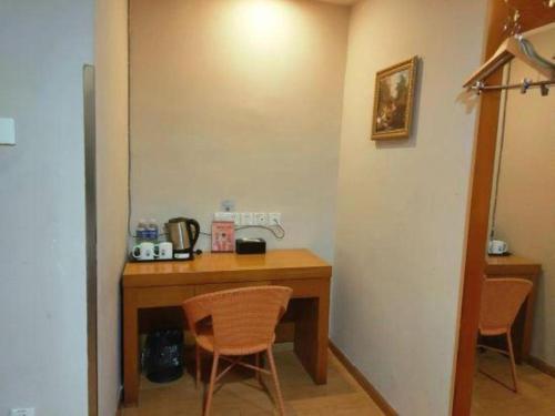 a room with a wooden table and two chairs at GreenTree Inn Hefei Huangshan Road Daxidi 1912 Express Hotel in Hefei