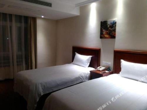 a hotel room with two beds and a phone at GreenTree Inn Yancheng Vehicle Administrative office Test Center Express Hotel in Yancheng