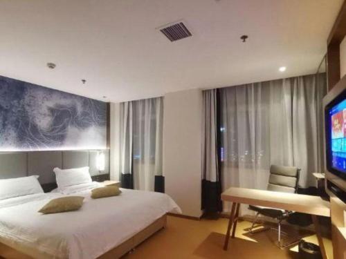 a bedroom with a large bed and a television at GreenTree Inn Taiyuan PinGYAng Road Business Hotel in Taiyuan