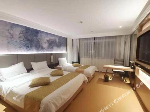 a hotel room with two beds and a flat screen tv at GreenTree Inn Taiyuan PinGYAng Road Business Hotel in Taiyuan
