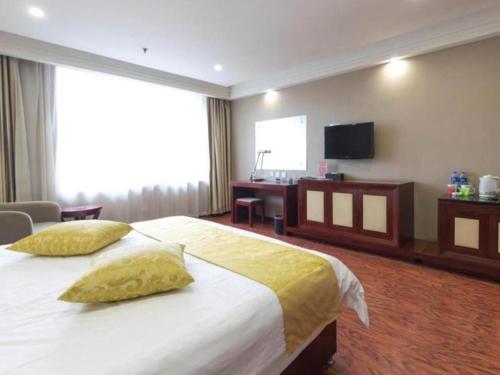 a hotel room with a bed and a television at GreenTree Inn Taiyuan PinGYAng Road Business Hotel in Taiyuan
