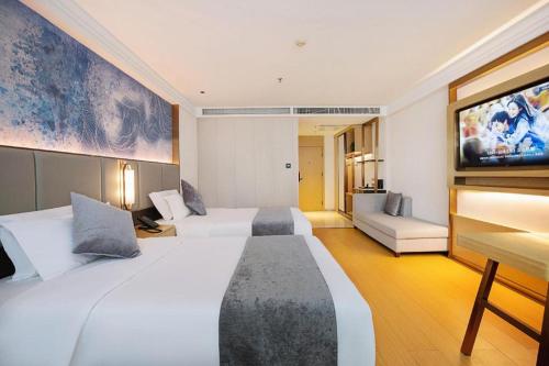 a hotel room with two beds and a flat screen tv at GreenTree Inn Taiyuan PinGYAng Road Business Hotel in Taiyuan