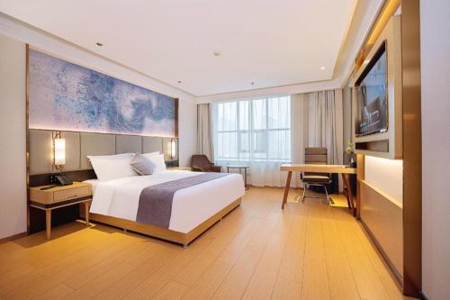 a hotel room with a bed and a television at GreenTree Inn Taiyuan PinGYAng Road Business Hotel in Taiyuan