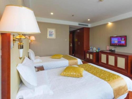 a hotel room with two beds and a television at GreenTree Inn Taiyuan PinGYAng Road Business Hotel in Taiyuan