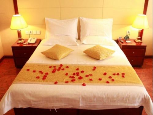 a bedroom with a bed with red hearts on it at GreenTree Inn Taiyuan PinGYAng Road Business Hotel in Taiyuan