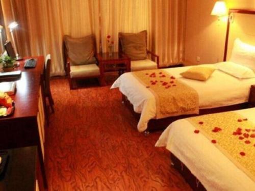 a hotel room with two beds and a chair at GreenTree Inn Taiyuan PinGYAng Road Business Hotel in Taiyuan