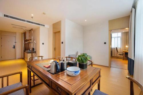 a living room with a wooden table in a room at GreenTree Inn Taiyuan PinGYAng Road Business Hotel in Taiyuan
