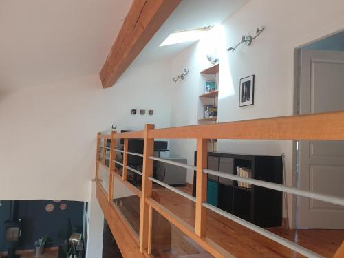 a staircase in a living room with wooden railings at Maison spacieuse face aux Pyrénées in Carla-Bayle