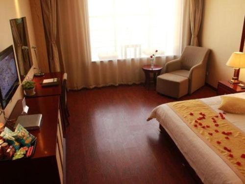 a hotel room with a bed and a chair at GreenTree Inn Taiyuan PinGYAng Road Business Hotel in Taiyuan