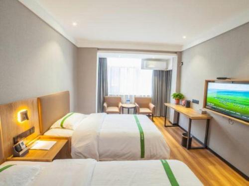 a hotel room with two beds and a flat screen tv at GreenTree Inn Hefei Chenghuangmiao San Xiao Kou Subway Station Hotel in Hefei
