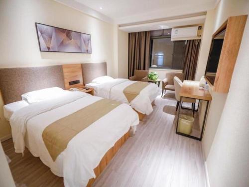 a hotel room with two beds and a desk at GreenTree Inn Hefei Chenghuangmiao San Xiao Kou Subway Station Hotel in Hefei