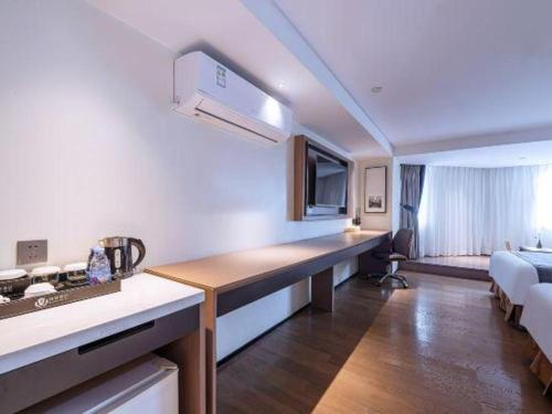 a hotel room with a kitchen and a bedroom at Zhongshan Louis Hotel in Zhongshan