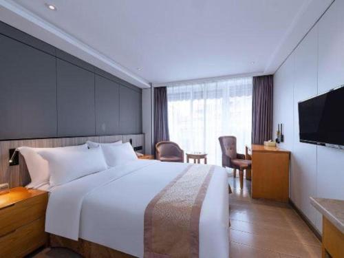 a hotel room with a large bed and a table at Zhongshan Louis Hotel in Zhongshan