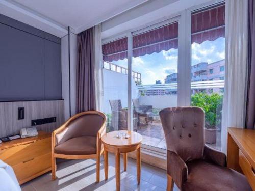 a room with a table and chairs and a large window at Zhongshan Louis Hotel in Zhongshan