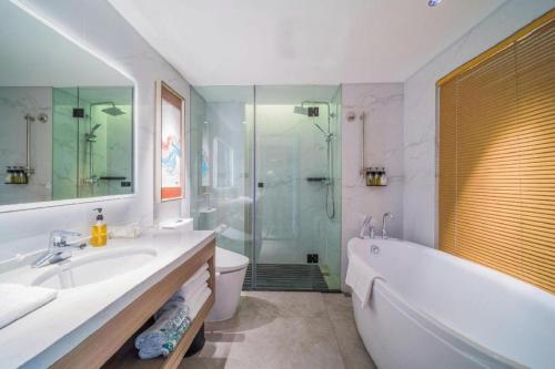 a bathroom with a tub and a sink and a shower at Zhongshan Louis Hotel in Zhongshan