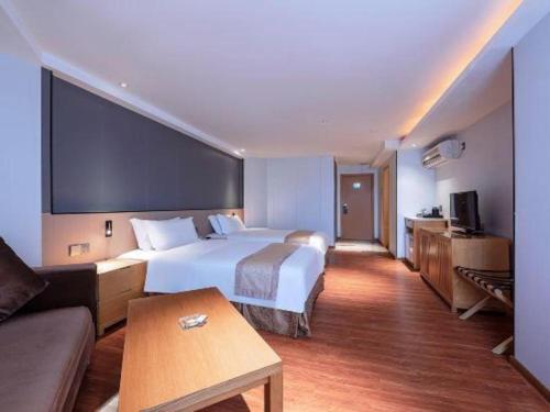 a hotel room with a large bed and a couch at Zhongshan Louis Hotel in Zhongshan
